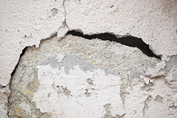 Cracked wall revealing uneven texture and layers of paint