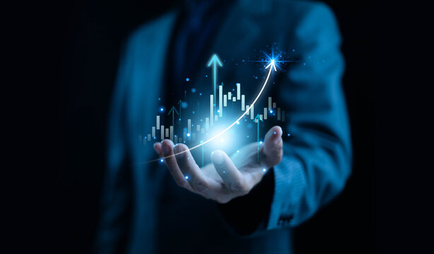 Businessman holding glowing financial growth chart with rising arrows and bar graph. Futuristic data analytics, digital finance, business success, investment growth, and technology innovation concept.