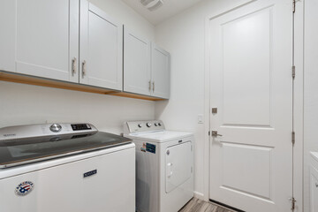 Fototapeta premium In a laundry room, there are two blue washers and matching dryers