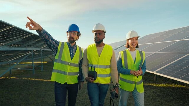 Team discusses solar panel installation at renewable energy site in afternoon sun