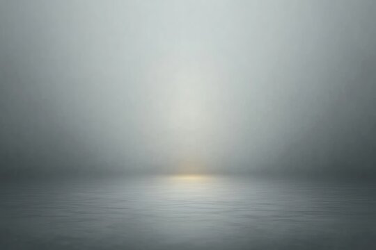 misty calm sea with gentle ripples and a soft glowing horizon in a minimal gray-blue atmosphere evoking quiet solitude
