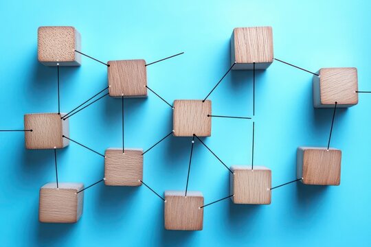 wooden cubes connected by thin black rods on a bright blue background forming an organized network, conveying a sense of order, collaboration and connectedness - Powered by Adobe
