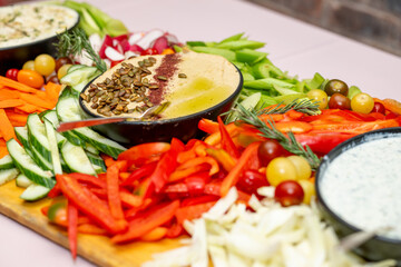 Tray with vegetables and dip at an event. Variety of sauce with peppers and carrots. 