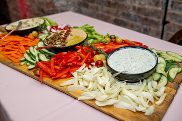 Tray with vegetables and dip at an event. Variety of sauce with peppers and carrots. 