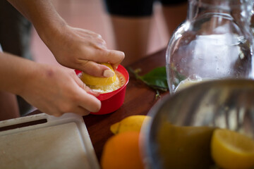 woman preparing and squeezing lemons for lemonade