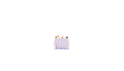 A small table covered with a white tablecloth, set with objects, against a black background
