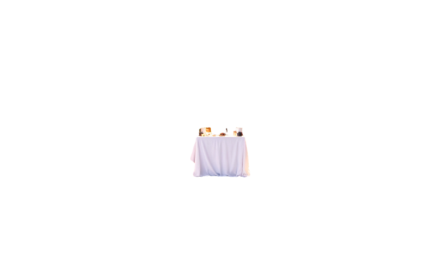 A small table covered with a white tablecloth, set with objects, against a black background