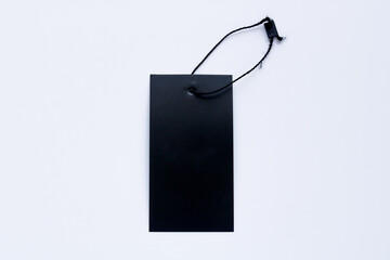 An overhead shot of a blank, black rectangular tag with a string, isolated on a white background.