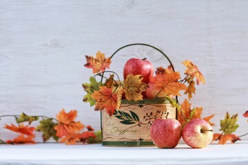 Apples in a basket, autumn leaves, still life