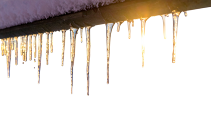 Close-up of icicles hanging from a metal pipe with snow on top, against a black backdrop