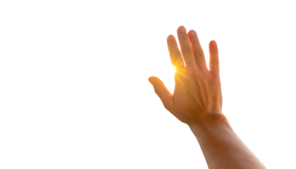 Palm held up, fingers spread, glows with light against a stark black background