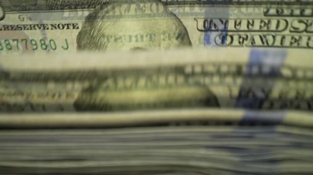 Finance and cash dollars concept. Counting dollars with electronic money counter machine. 100 dollar bills counted in money counting machine. Cash money dollars into banknote counter.