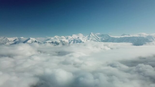 Aerial view from above of clouds. Rosa Khutor Ski Resort, mountains covered by snow in Krasnaya Polyana, Russia.