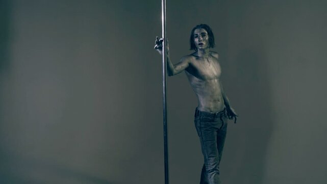 Sexy man pole dancer. Guy does gymnastic exercises on pole dance. Pole dancing for slim fitness body. Flexibility. Pole dance. Pylon dancing strength, flexibility, and grace. Strip dancer.