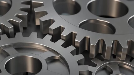 A close-up view of several interlocking metal gears and cogs from a complex machine.
