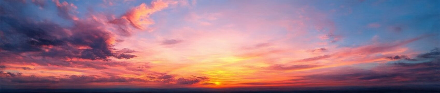 Expansive sunset sky with glowing sun on the horizon, layered colorful clouds and tranquil pastel hues evoking peaceful awe