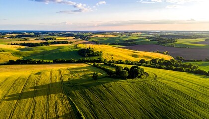 Aerial view of rural landscape. Fields of grain, green hills, blue skies, and soft light