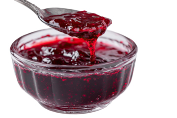 Spoon lifting dark red berry preserve from clear glass bowl