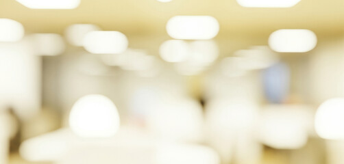 Blurred indoor scene with bright white oval lights and warm yellow tones, forming a soft glowing ambience that feels cozy and calm with gentle illumination across the room.