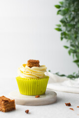 green cupcake with buttercream frosting and a sponge cake garnish on white background, tall buttercream frosting on green cupcakes