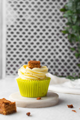 green cupcake with buttercream frosting and a sponge cake garnish on white background, tall buttercream frosting on green cupcakes