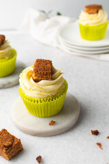 green cupcake with buttercream frosting and a sponge cake garnish on white background, tall buttercream frosting on green cupcakes
