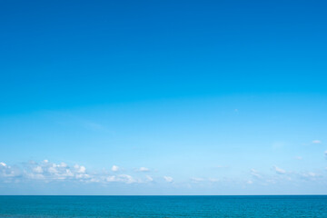 Obraz premium Nature of the ocean and blue sky Summer with sunshine, sandy beaches, clear blue waters sparkling against the blue sky. on an island with good ecology and environment Background for summer vacation