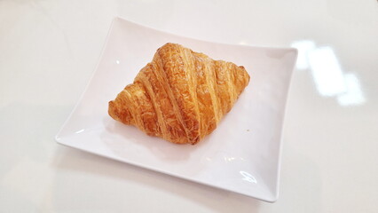 Fresh Golden Croissant Pastry on White Plate for Gourmet Bakery Promotion