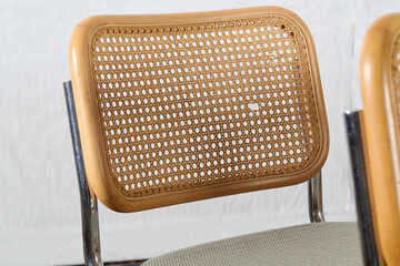 Detailed view of a break in the woven cane backrest framed in wood on vintage cantilever chair
