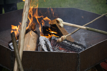 Campfire scene with bread being roasted over the flames, evoking warmth and nostalgia.