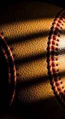 Close up macro shot of a textured leather baseball with red stitching and dramatic lighting