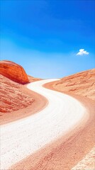 A winding dirt road traverses a desert canyon, flanked by textured sandstone cliffs under a clear blue sky with a single fluffy cloud.