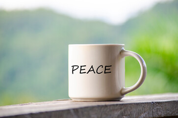 Peace text on a mug with nature beauty background.