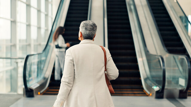 Woman, escalator and airport for travel with bag, luggage and walk for global departure. Mature person, business trip and at stairs, immigration or international flight at terminal for corporate job - Powered by Adobe