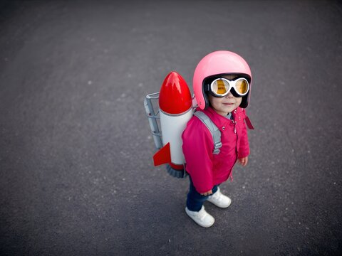 Child in pink astronaut helmet and jetpack ready for adventure