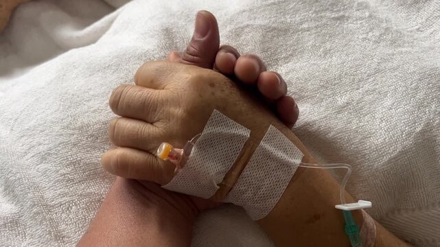 A Touching Gesture of Comfort: A tender moment captured, showing two hands clasped together, conveying comfort, support, and empathy. The image speaks volumes about care and the human bond.