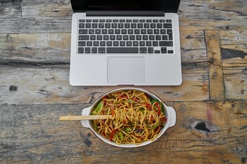 Laptop Workspace With Noodle Bowl