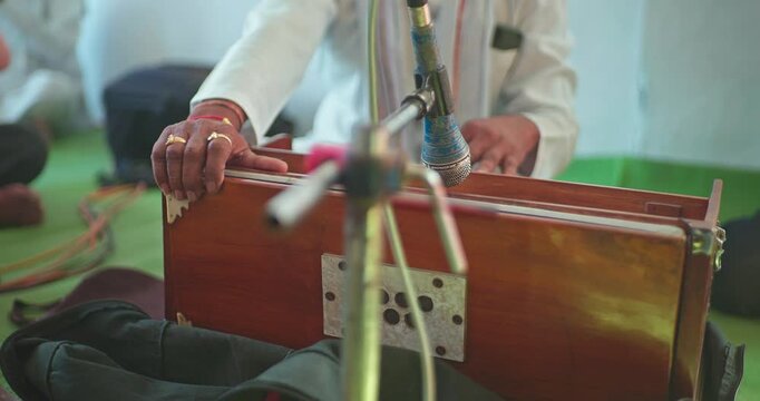 Cinematic Shot of Harmonium Playing During Devotional Program in Mandir