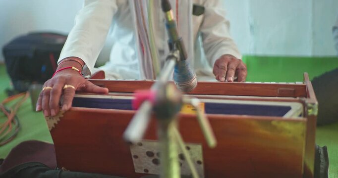 Cinematic Shot of Harmonium Playing During Devotional Program in Mandir