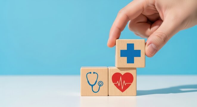 Hand stacking wooden blocks with icons of a stethoscope, heart rhythm, and a blue cross, representing healthcare