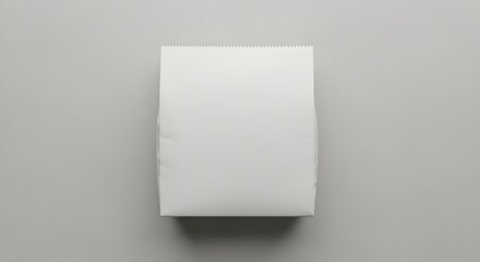 Minimalist top view of a blank white paper block on a neutral gray background