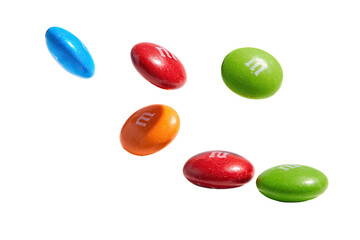 Six candy-coated chocolate pieces, varying bright colors, isolated against a black background