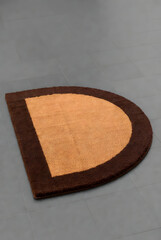 Semi-Circle Coir Doormat with Brown Border on Gray Floor (3D Render)