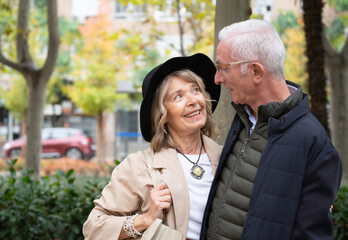 Portrait of senior woman looking lovingly at her partner while smiling in a park
