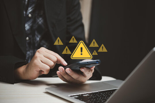 System hacked warning alert. Businessman use smartphone with warning sign for cyber attack. Ransomware, Virus, Spyware, Malware or Malicious software, Data breach, Cyber security and cybercrime.