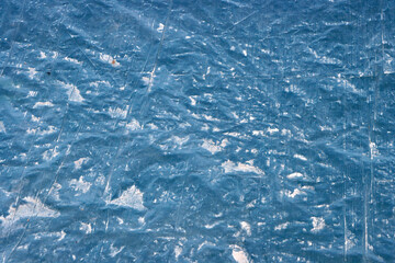 Ice-blue textured plastic surface with reflective folds and crystalline distortions ideal for abstract backgrounds and design overlays