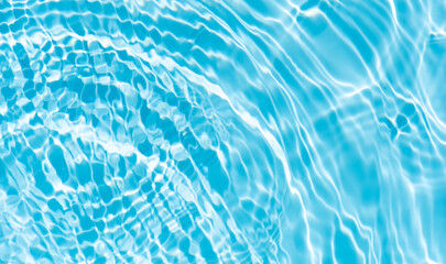 Blue water with ripples on the surface. Defocus blurred transparent blue colored clear calm water surface texture with splashes and bubbles. Water waves with shining pattern texture background.