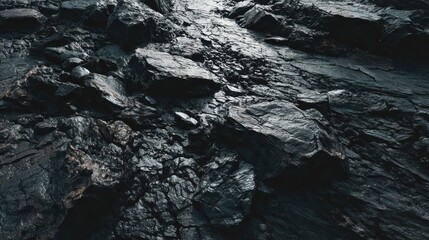 Dark rocky terrain showing jagged stones and textured surfaces under natural lighting in a rugged outdoor setting