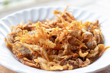 Crispy fried mushroom garnish in white bowl, golden brown texture adding savory crunch and warm aroma to dishes