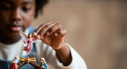 Child playing with nativity scene, embracing Christmas religious tradition